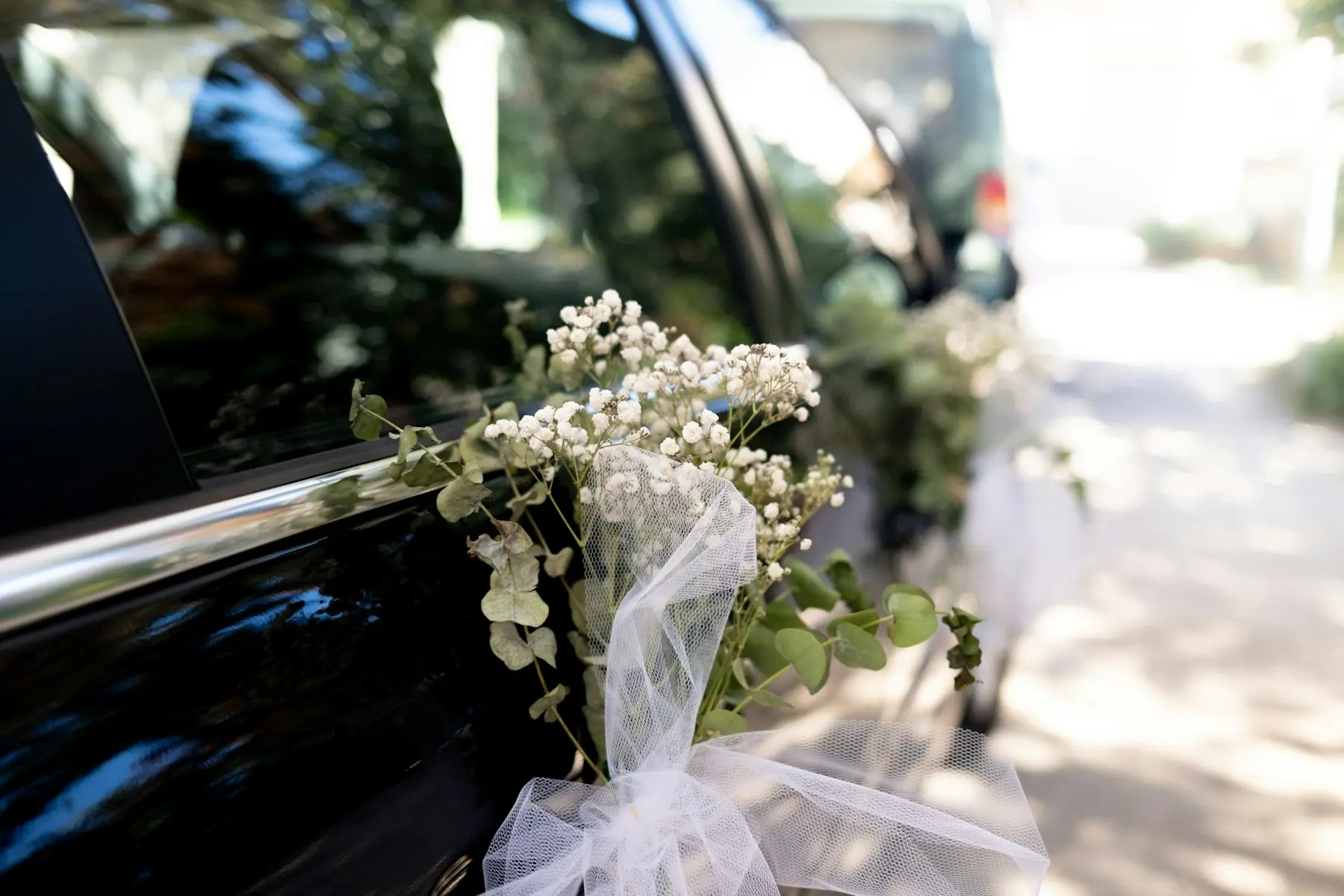 Fiori bianchi da sposa sulla portiera di un'auto
